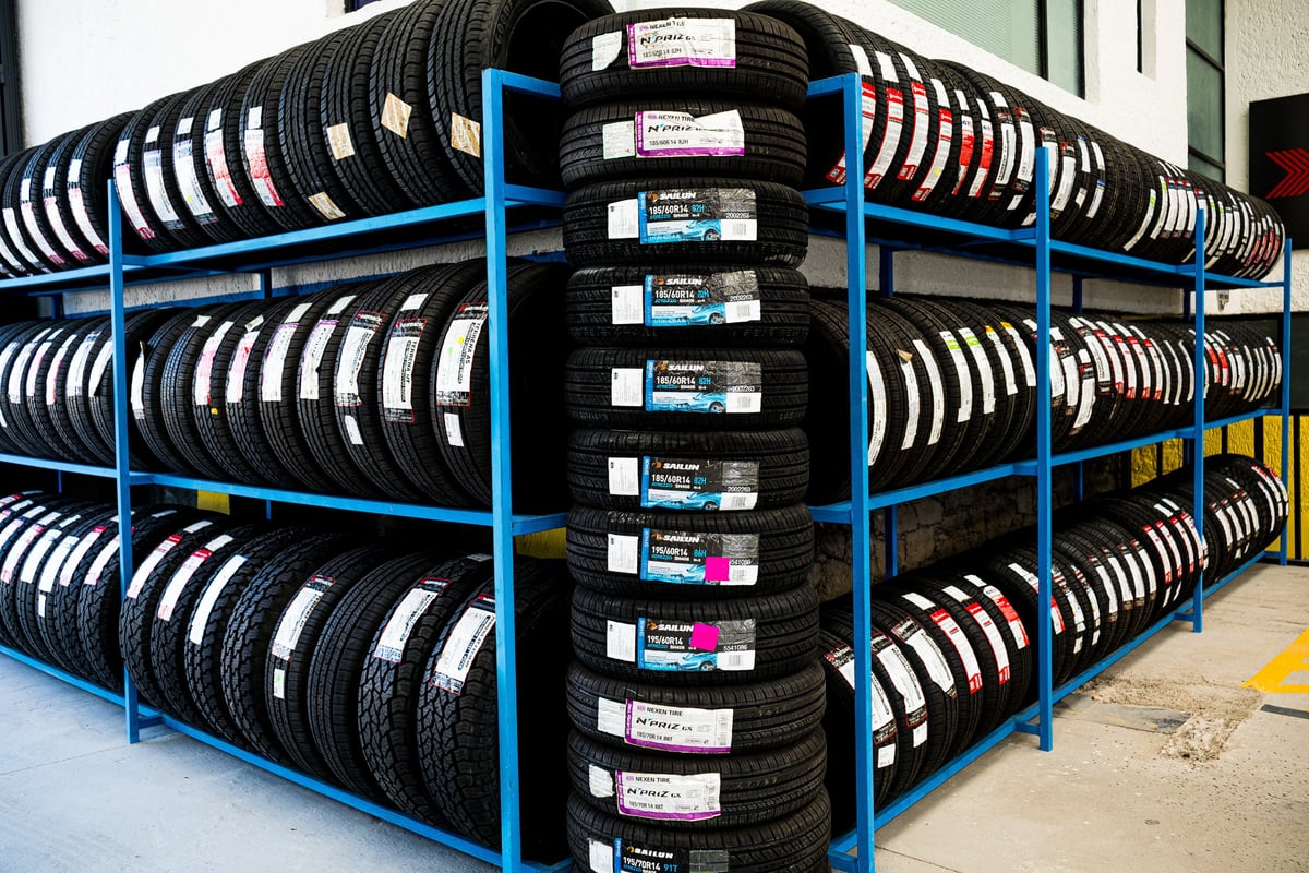 Industrial tire storage rack with multiple shelves holding stacked car tires organized by size and type