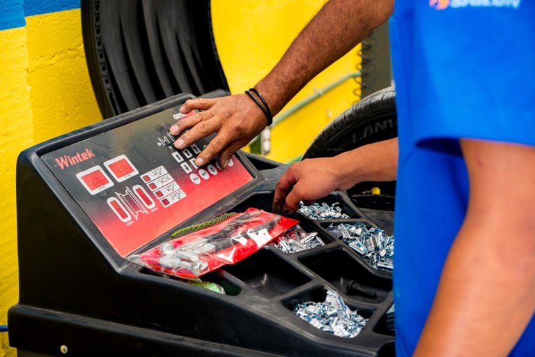 Persons hand operating a touchscreen interface on a waste bin with yellow and blue colored sections for recycling sorting
